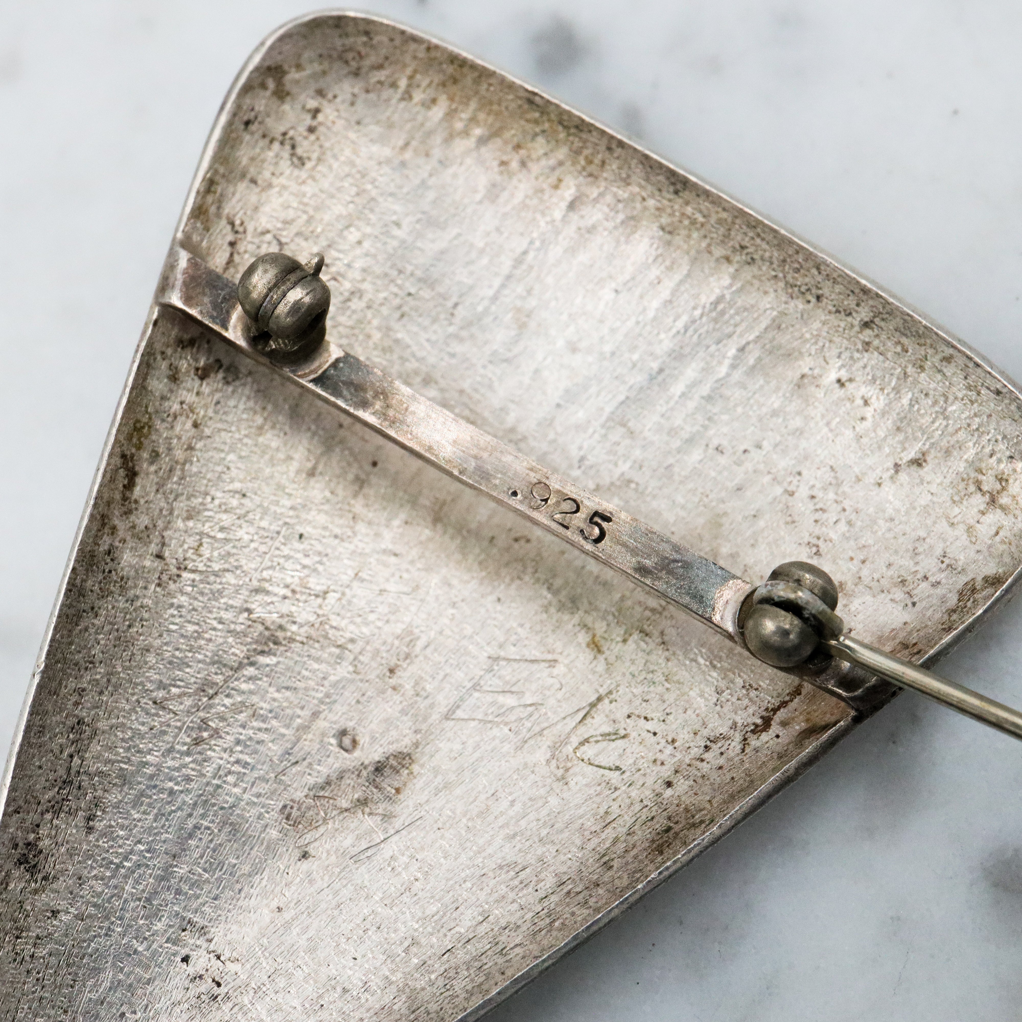 1987 pair of brushed sterling mask brooches by Modernist artist Elizabeth Earle
